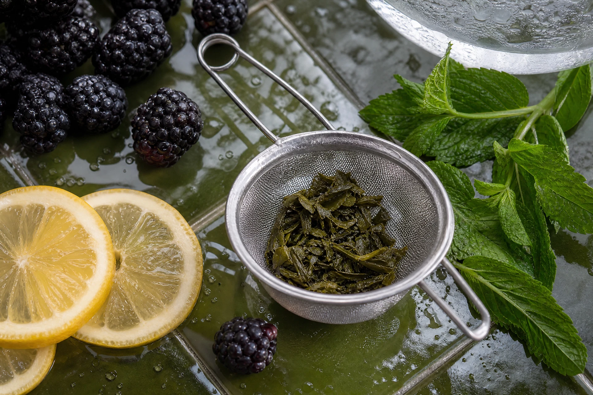 Ingredients for a blackberry green tea cooler including fresh fruit and chilled tea.
