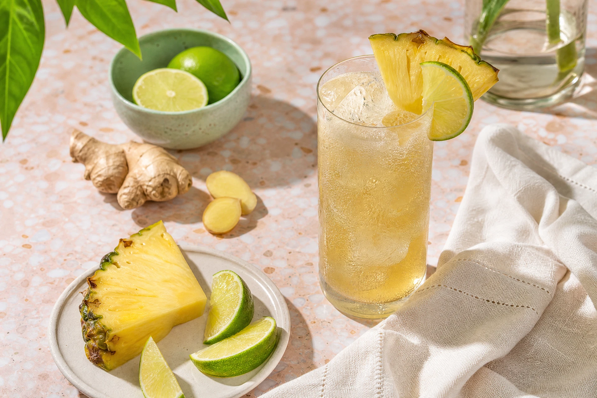 Ingredients for a pineapple ginger mocktail arranged on a wooden counter.