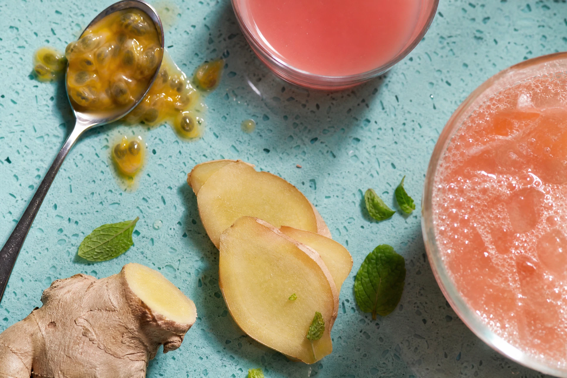Close-up of fresh passionfruit and guava nectar being poured into a cocktail shaker.