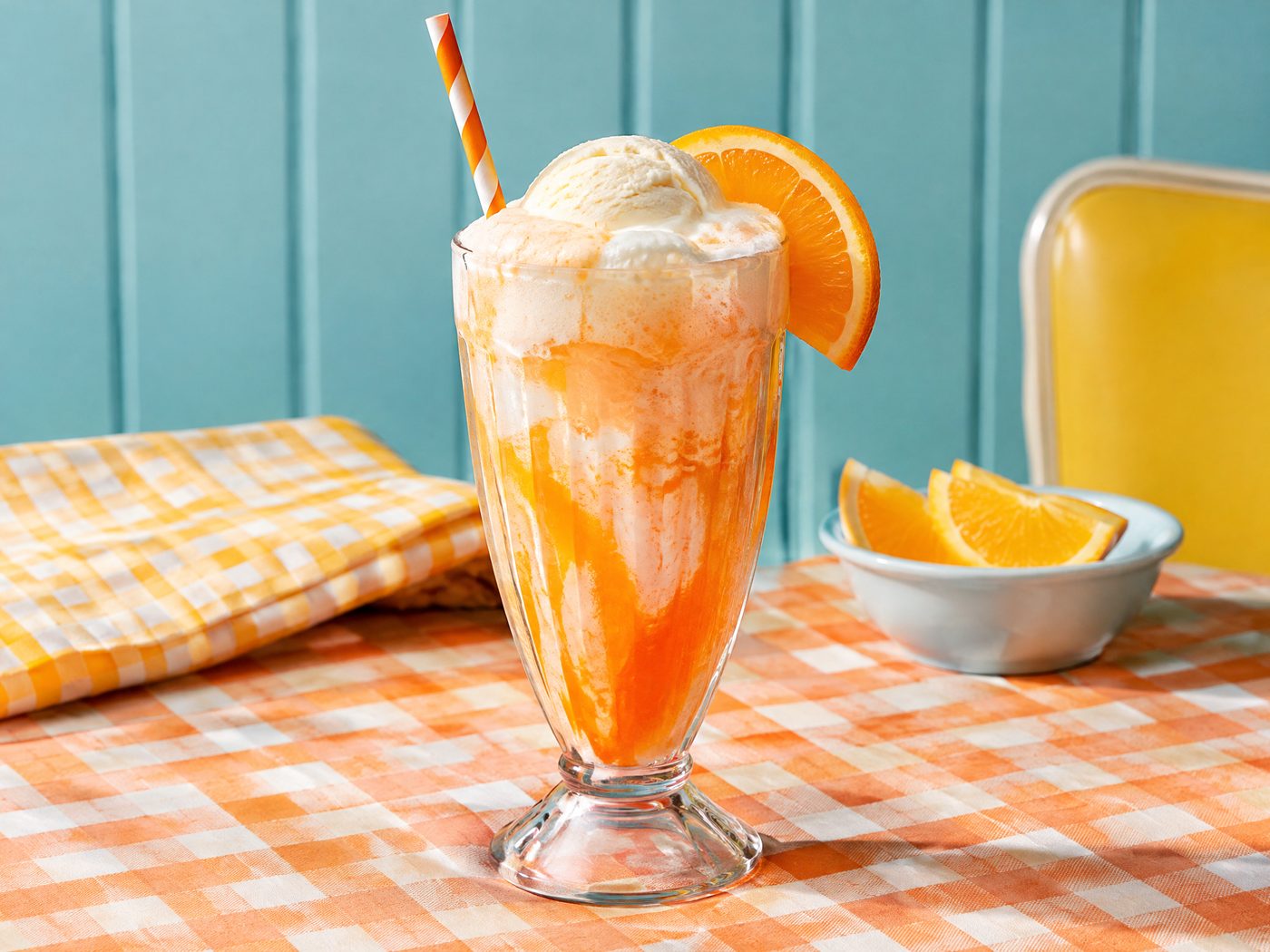 Orange Creamsicle Float mocktail with vanilla foam, orange slice, and cheerful retro styling